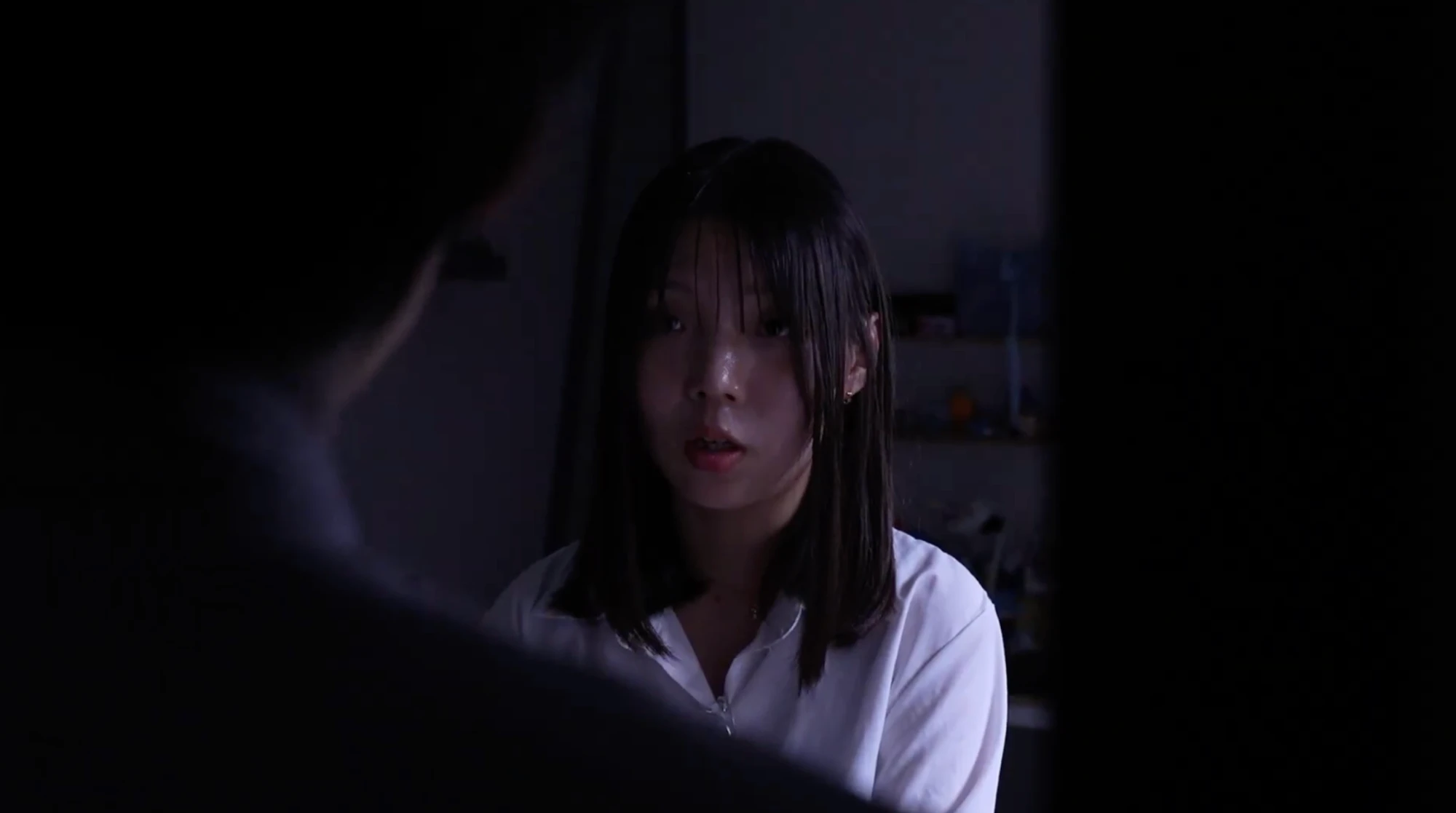 어두운 방에서 상대를 바라보는 인물
